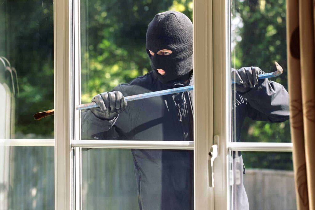 Einbruchversuch an einem Fenster als Symbol für Einbruchschutz und Alarmanlagen