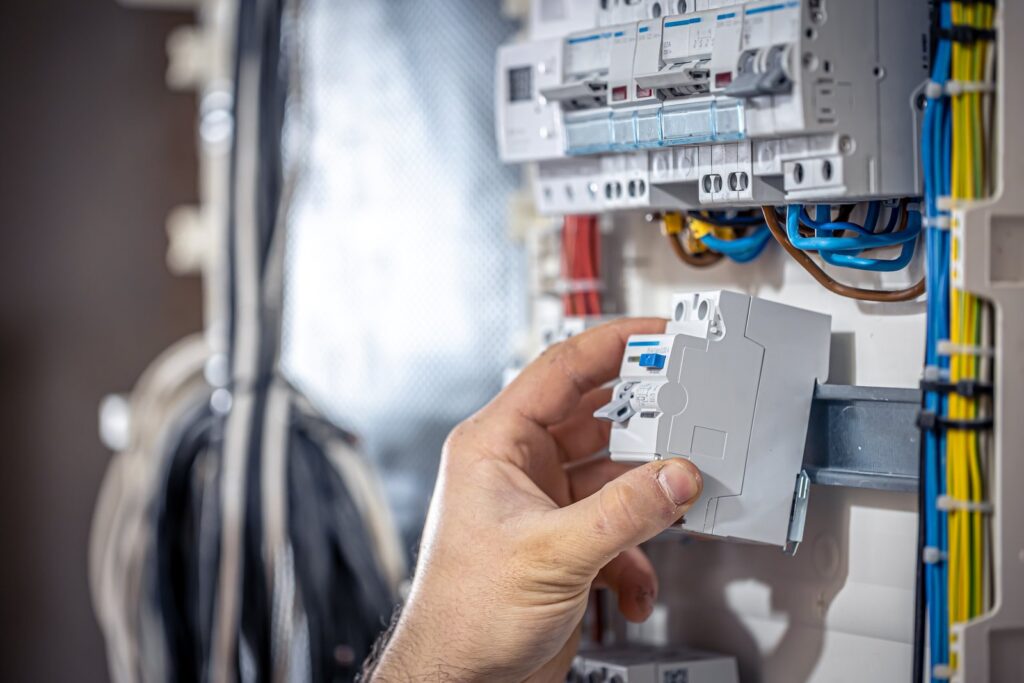 Elektriker bei Arbeiten an einer elektrischen Unterverteilung