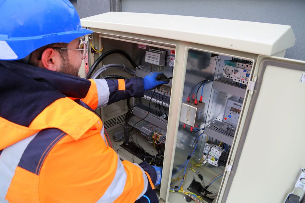 Servicetechniker bei der Prüfung einer elektrischen Anlage mit Messgerät